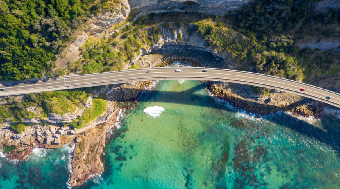 Infrastructure photo of cars on bridge over beautiful coastline