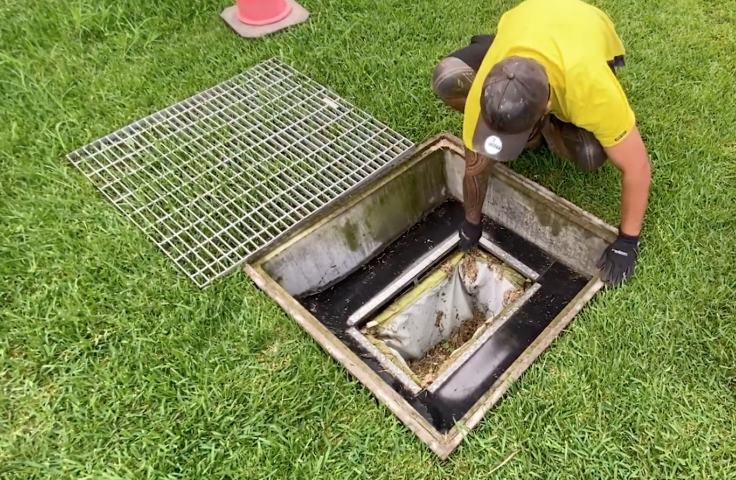 Worker removes the stormwater filter from a drain
