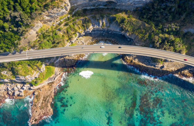 Infrastructure photo of cars on bridge over beautiful coastline